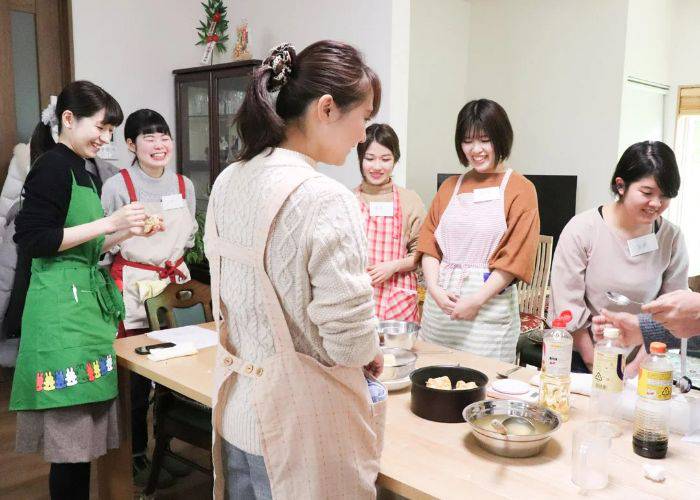 A smiling room of guests at a mochi-making class in Fushimi.